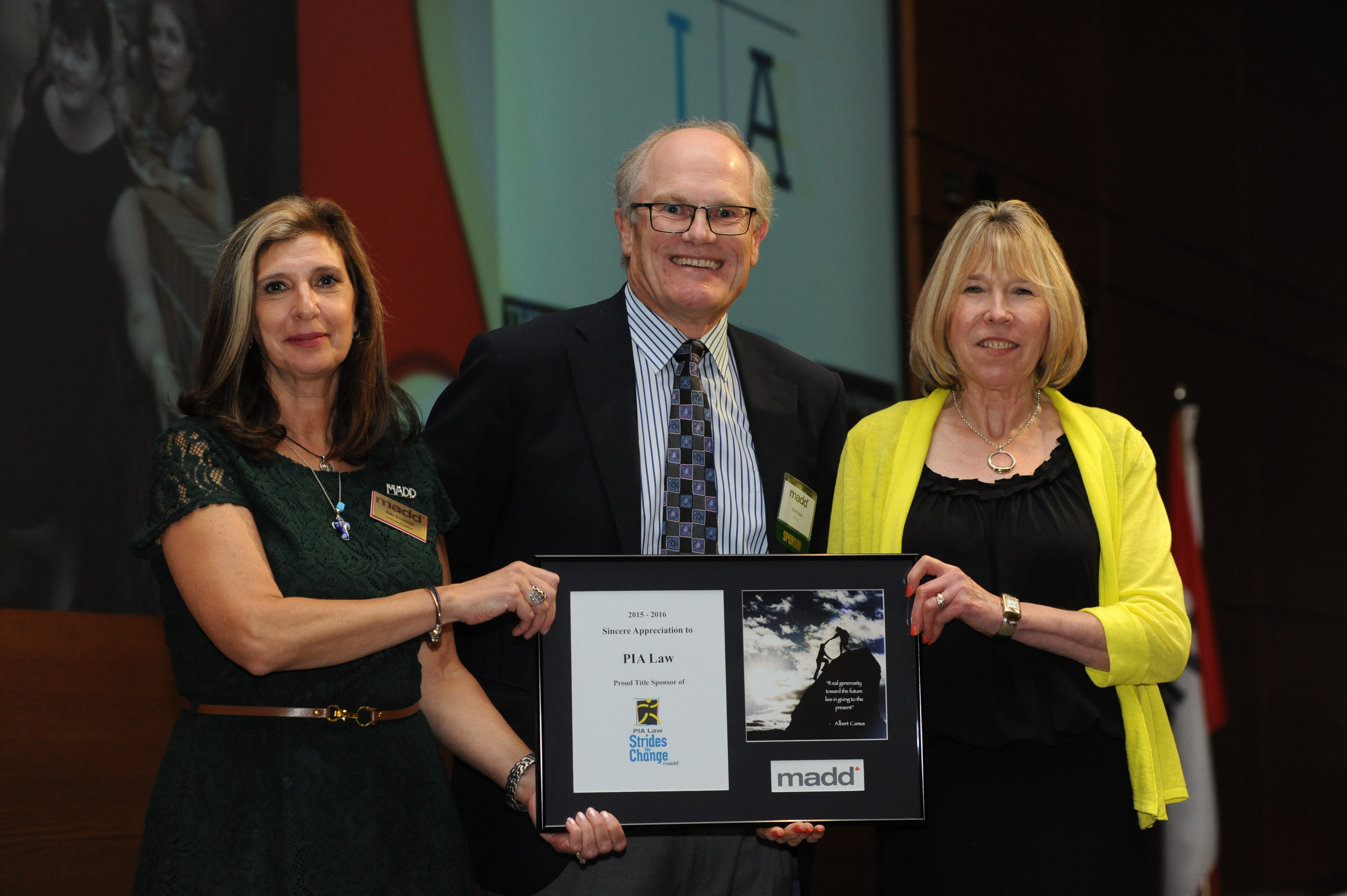 Alan Farrer, Managing Lawyer PIA Law, accepts an award in recognition of PIA Law's support of MADD Canada and Strides for Change. Presenting the award are Angeliki Souranis, National President, MADD Canada (left) and Margaret Stanowski, Chair of the National Board of Directors.